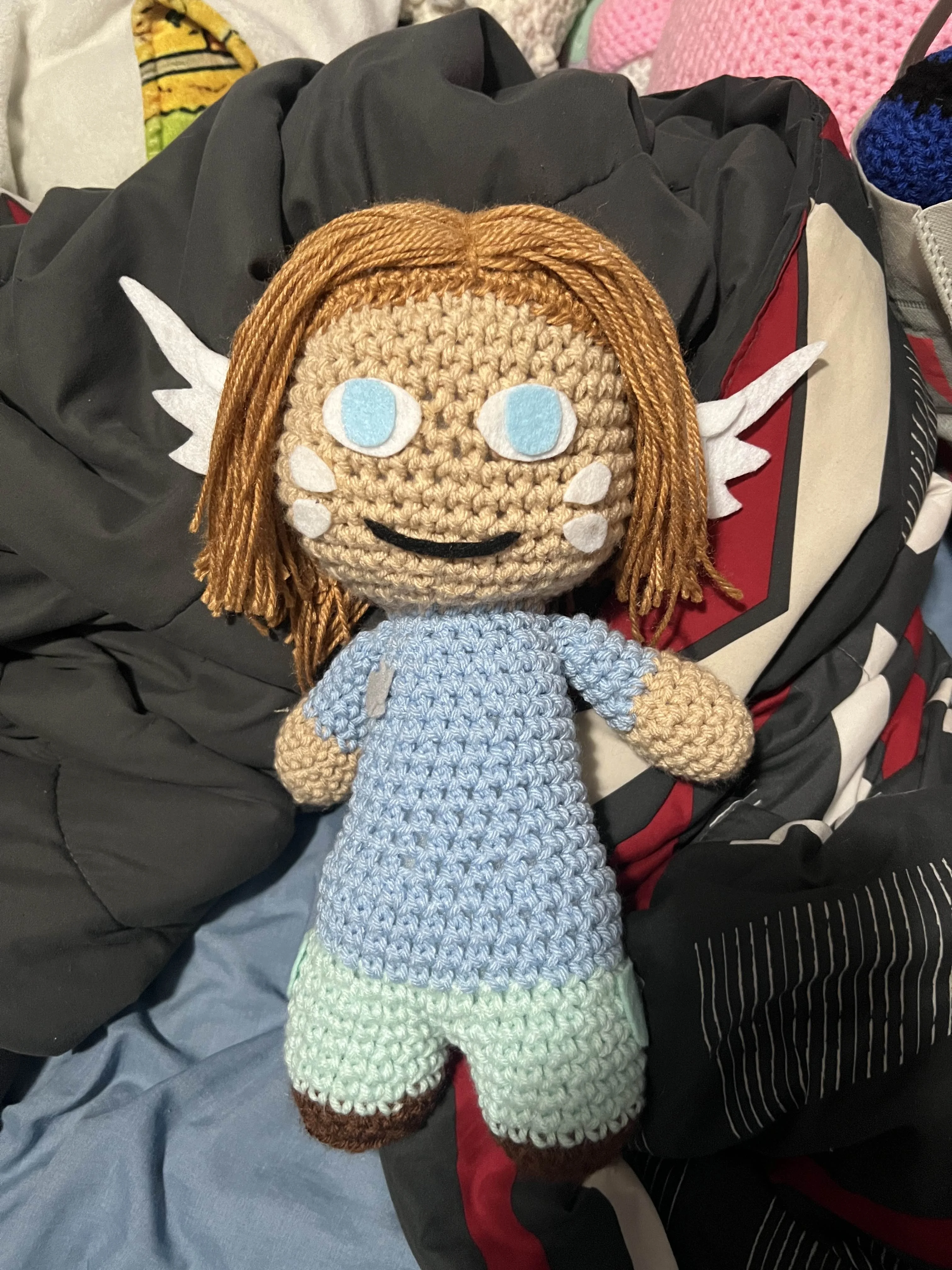 Tanned skin doll with white wings on head.